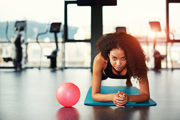 Woman does a plank on an exercise mat